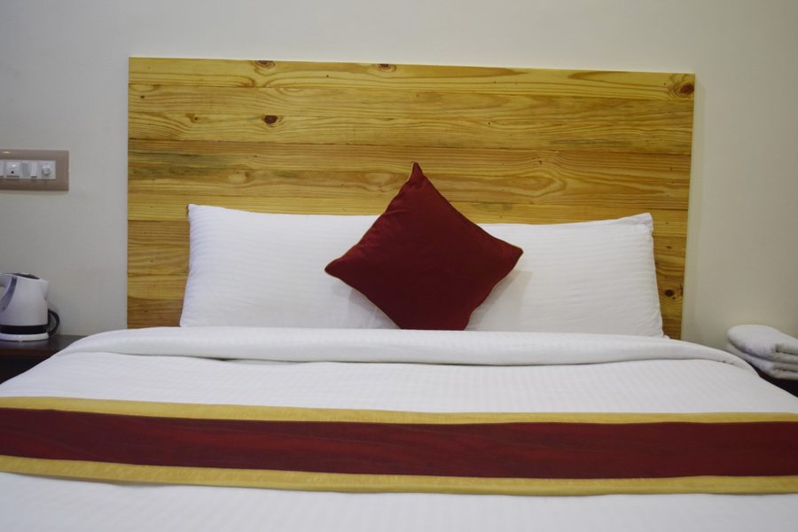 Premium wooden headboard close-up with red accent pillow